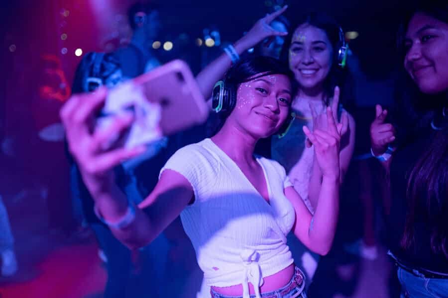 Friends taking a photo together in a purple and blue party environment