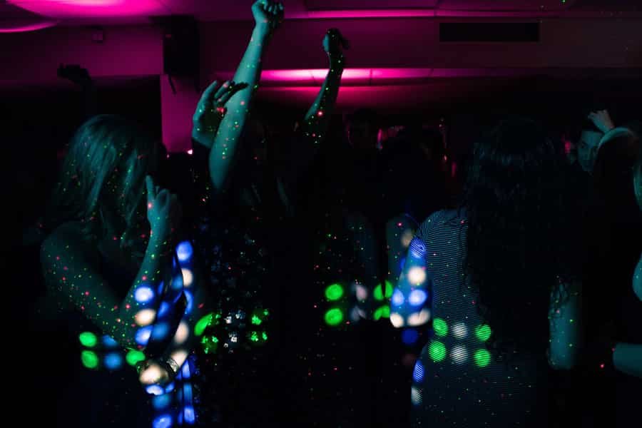 Nightclub audience covered in colorful projected light patterns